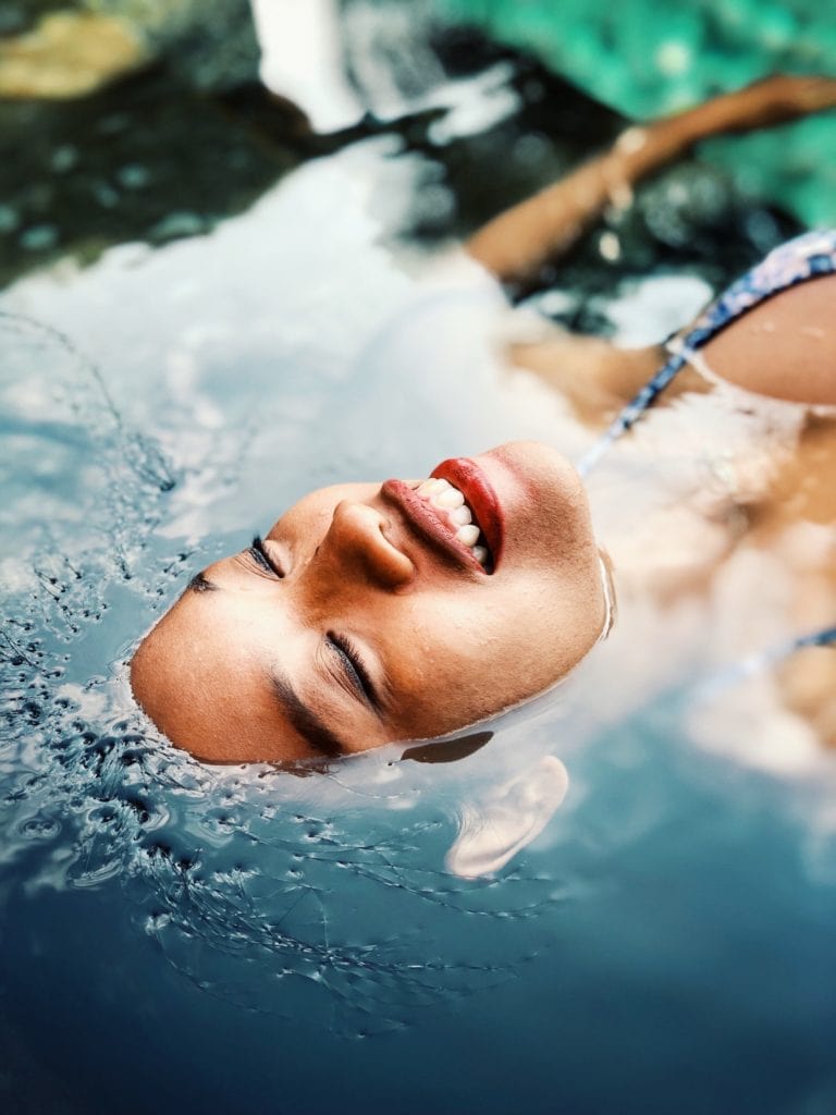 Frau badet und hält ihren Kopf unter Wasser