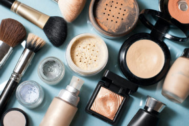 Powder jars and make-up bottles on turquoise background