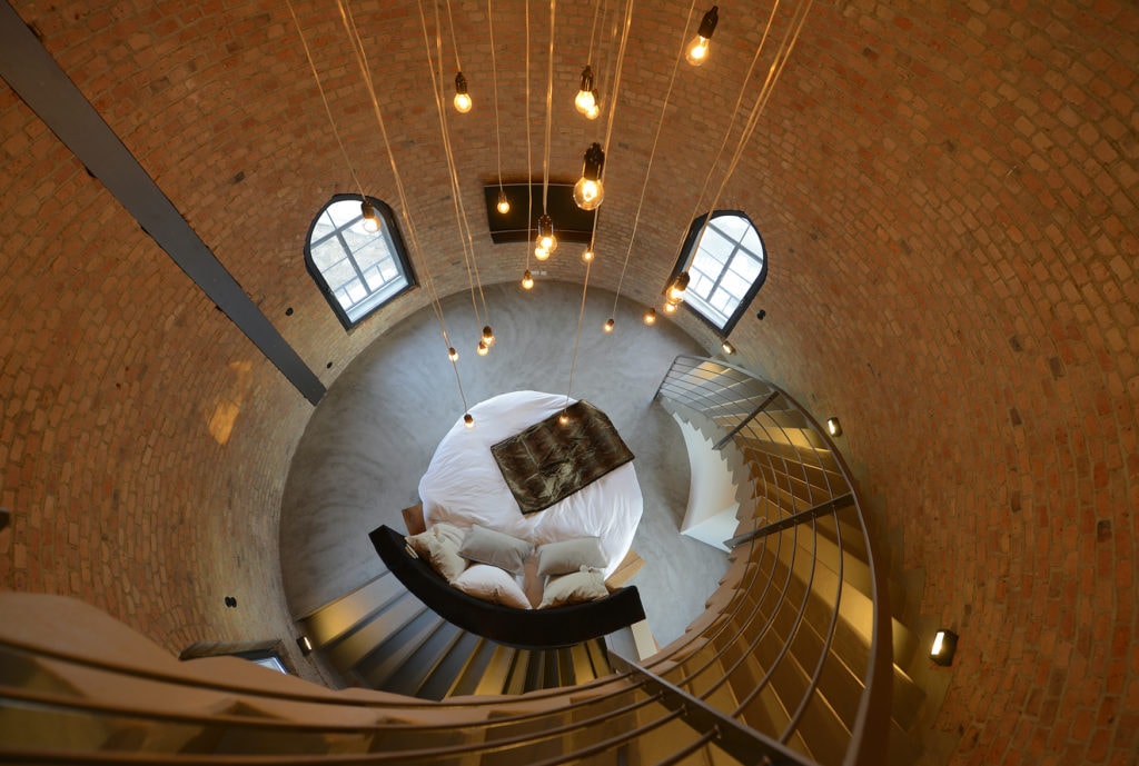 Blick von oben in ein rundes Hotelzimmer mit einem runden Bett im Wasserturm