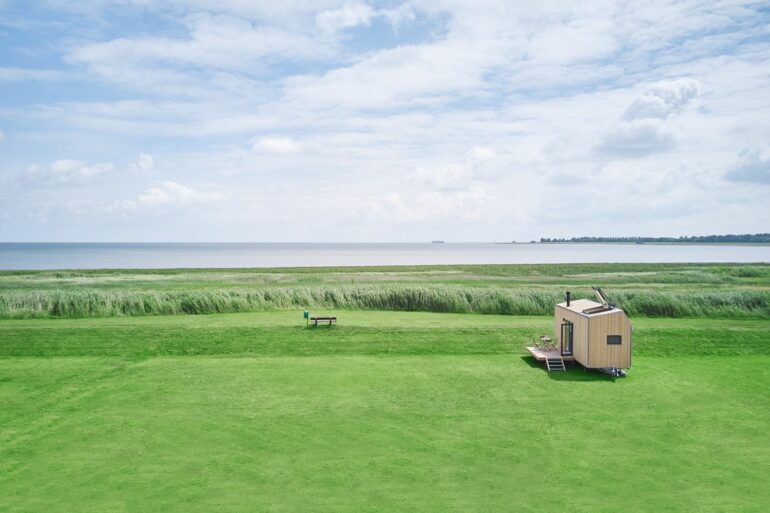 Ein einzelnes Tiny House steht am Nordsee-Deich in Wangerland