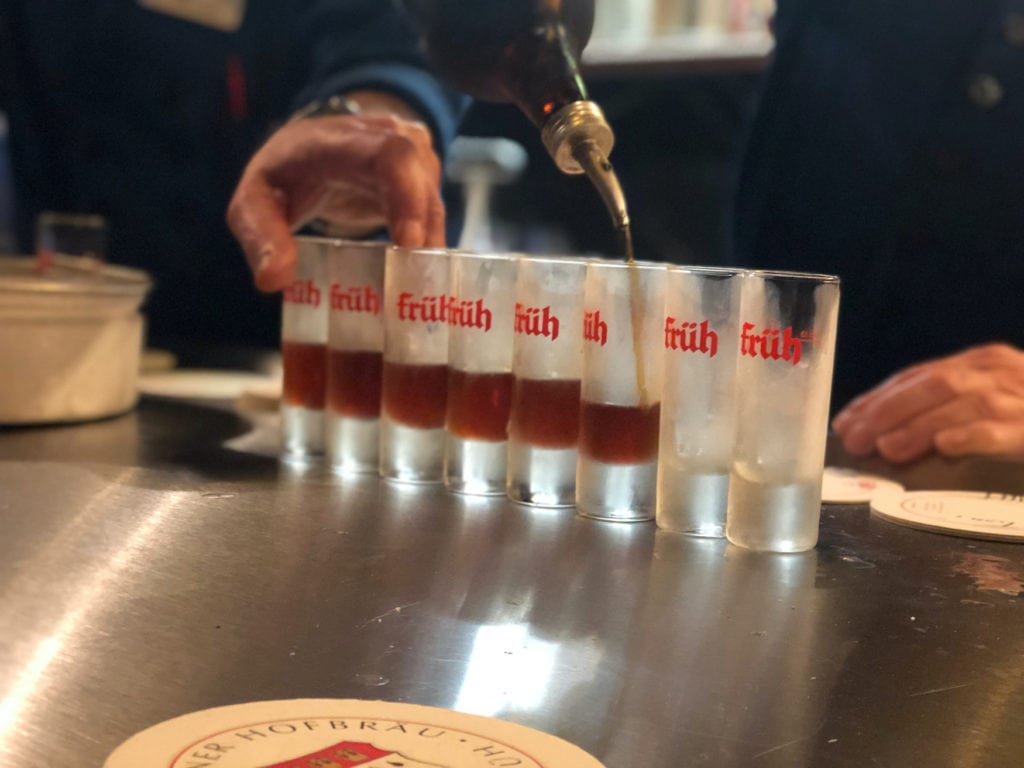 Köbes fills shot glasses at Früh Brauerei in Cologne