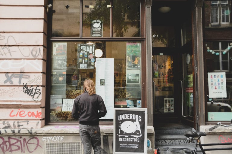 Mann steht vor Underdog Schallplattenladen in Köln und betrachtet das Schaufenster