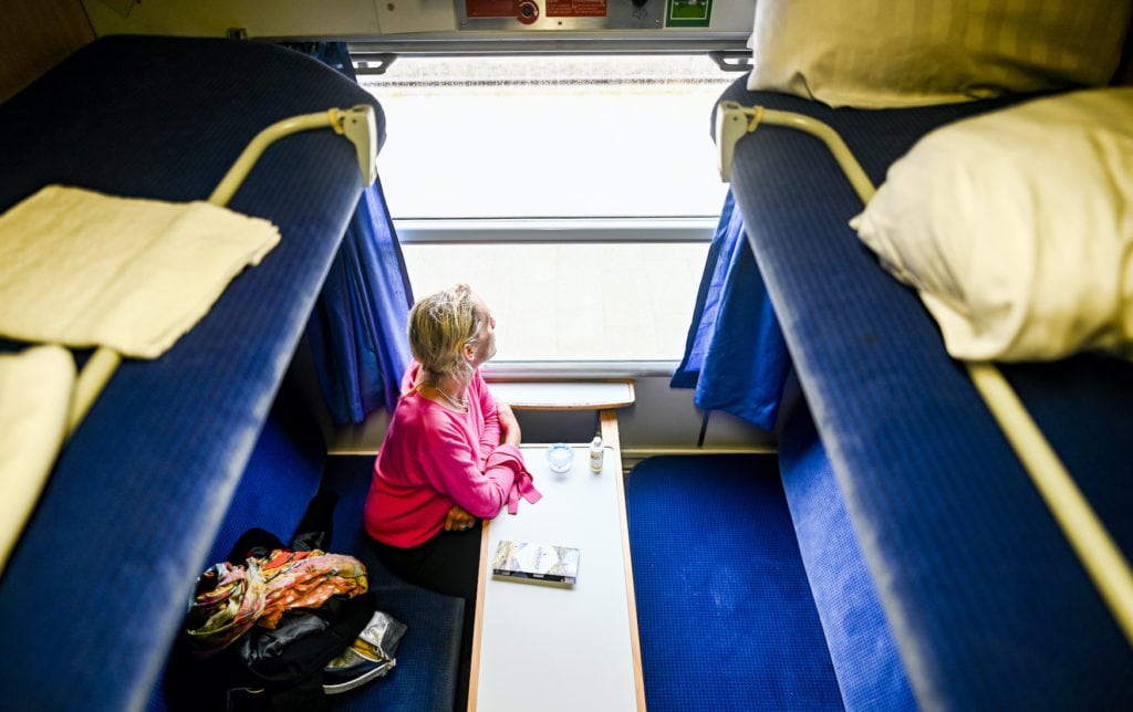 Eine Frau wartet in einem Abteil des neuen Alpen-Sylt-Nachtexpress von Sylt nach Salzburg des Bahnanbieters RDC auf die Abfahrt des Zuges.