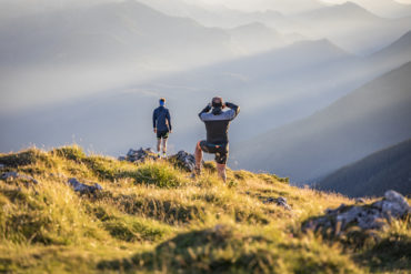 Zwei Männer sind auf Berg im Berchtesgadener Land gewandert und genießen die Aussicht