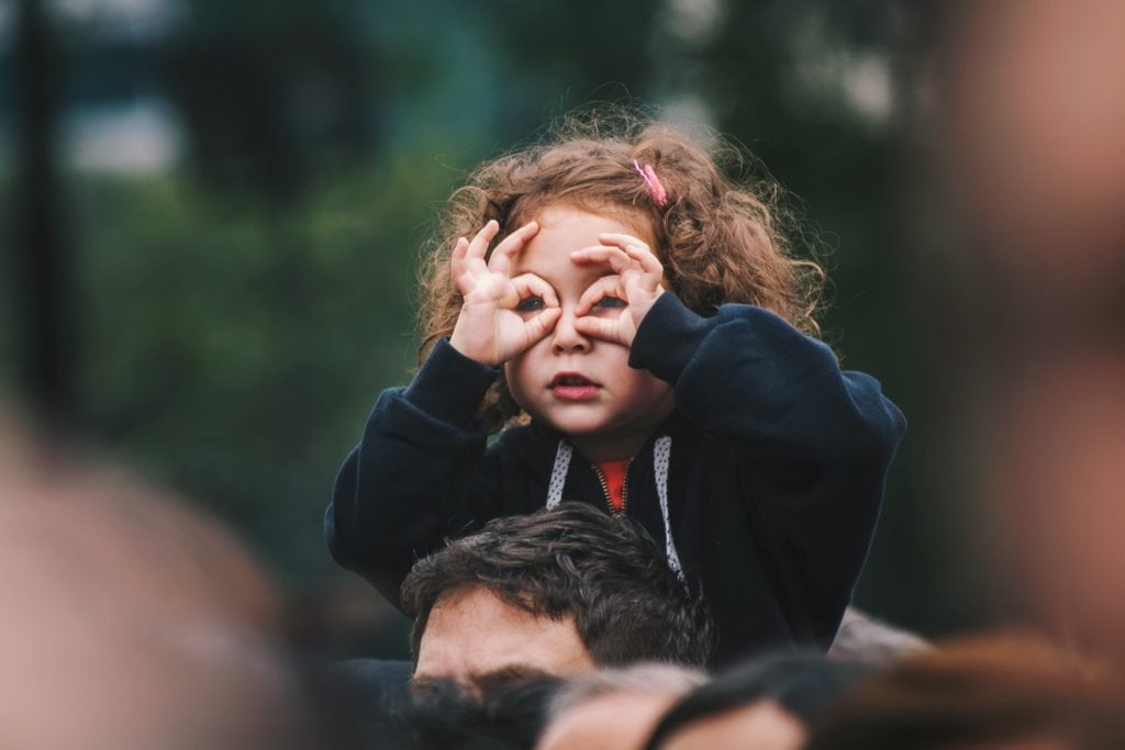 Little girl shaping her hands into binoculars