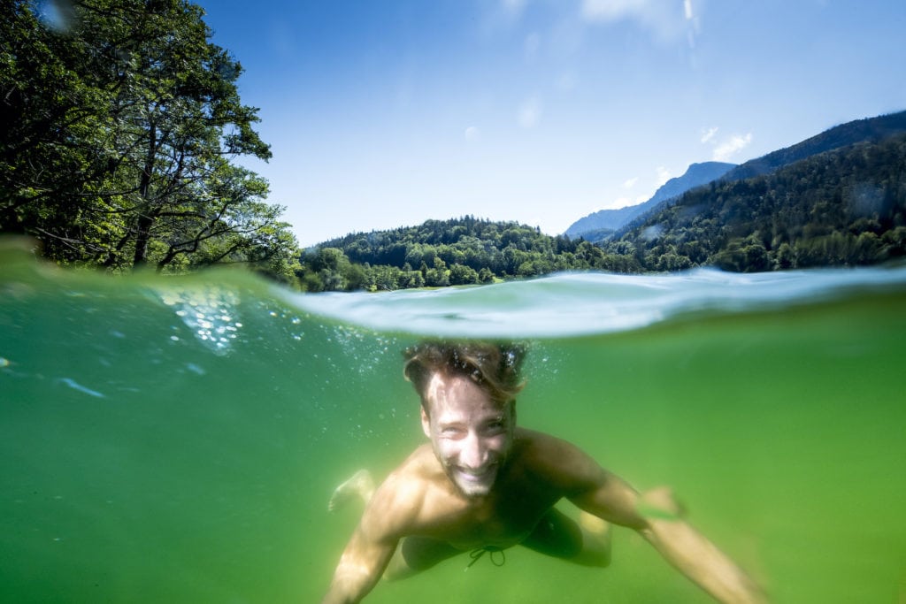 Mann taucht in einem See in der Nähe von Bad Reichenhall im Berchtesgadener Land