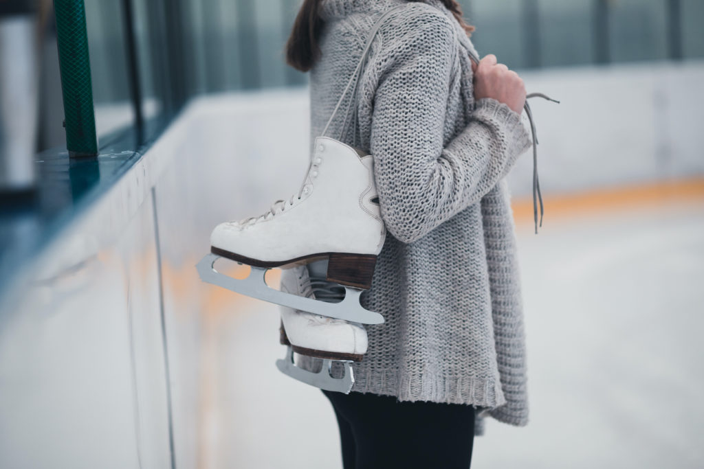 Frau mit Schlittschuhen in einer Eishalle 