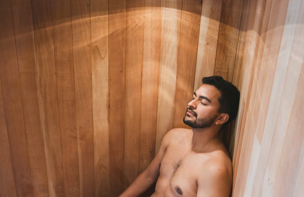 Man relaxing in sauna with his eyes closed