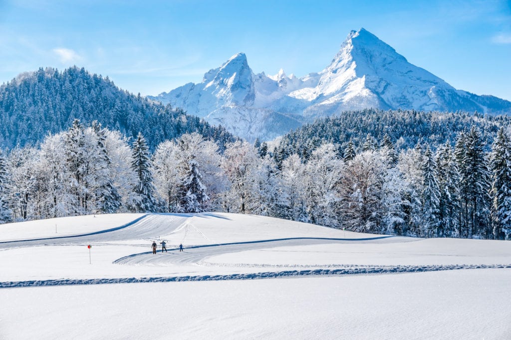 Panoramic view of beautiful winter landscape in the Bavarian Alps with cross-country slopes and famous Watzmann massif in the background