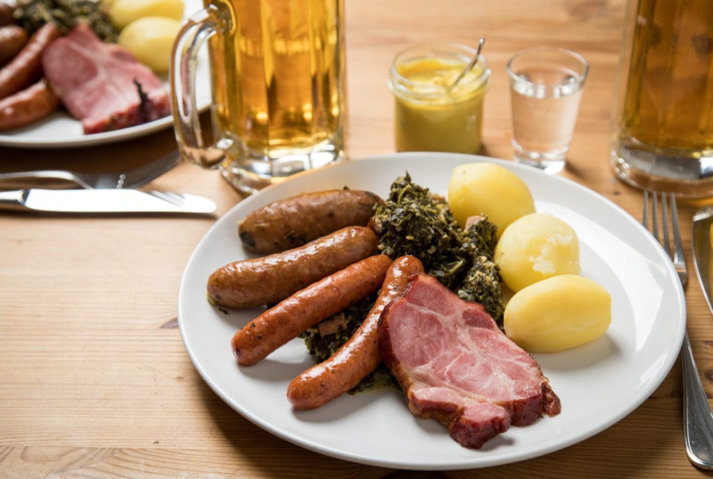 Cabbage and pickle served with potatoes and Kassler in a restaurant