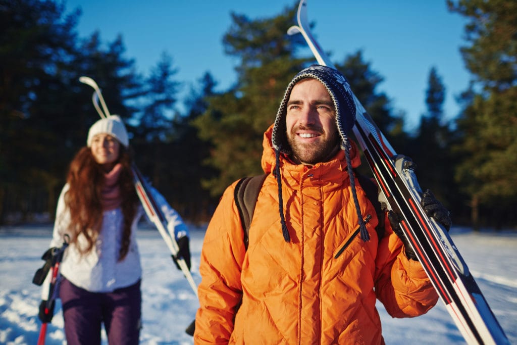 couple with cross country skis in snowy landscape