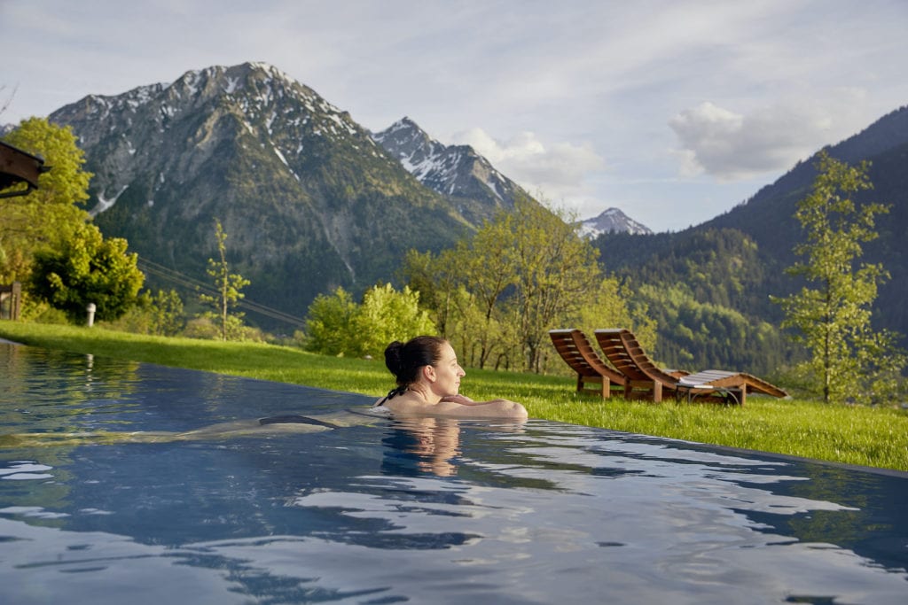 Frau liegt im Outdoor-Pool des Hotel Prinz-Luitpold-Bad