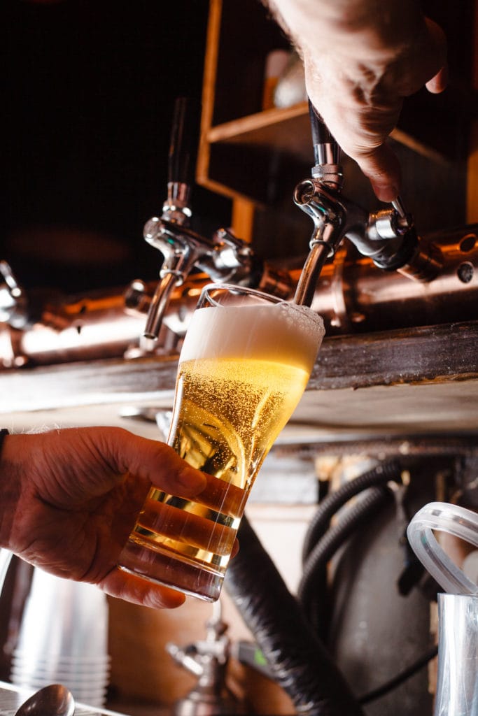 Wirt zapft Bier in Kneipe in NRW