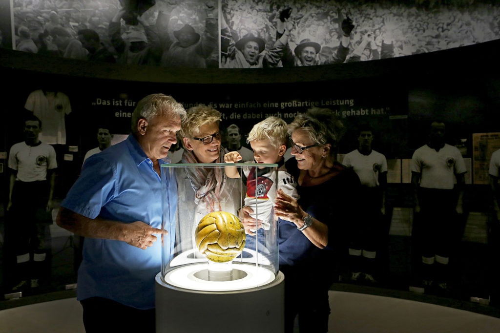 Family looks at soccer trophy in German football museum