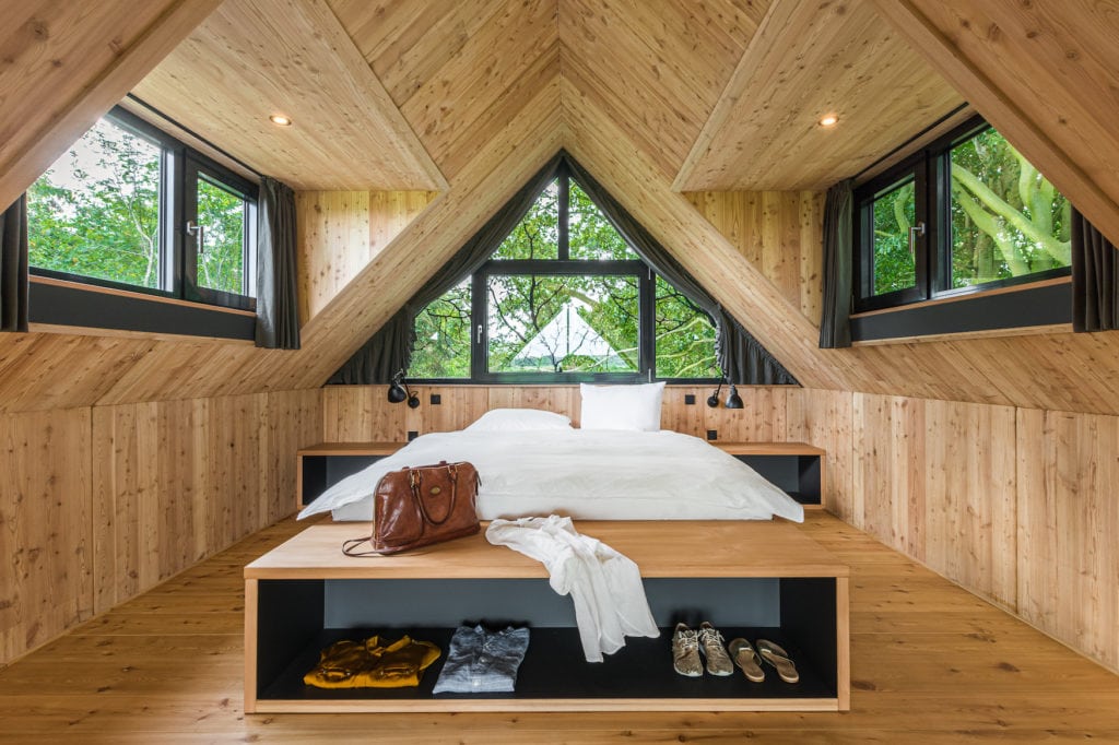 Holzverkleidetes Schlafzimmer in einem Design-Baumhaus in Deutschland