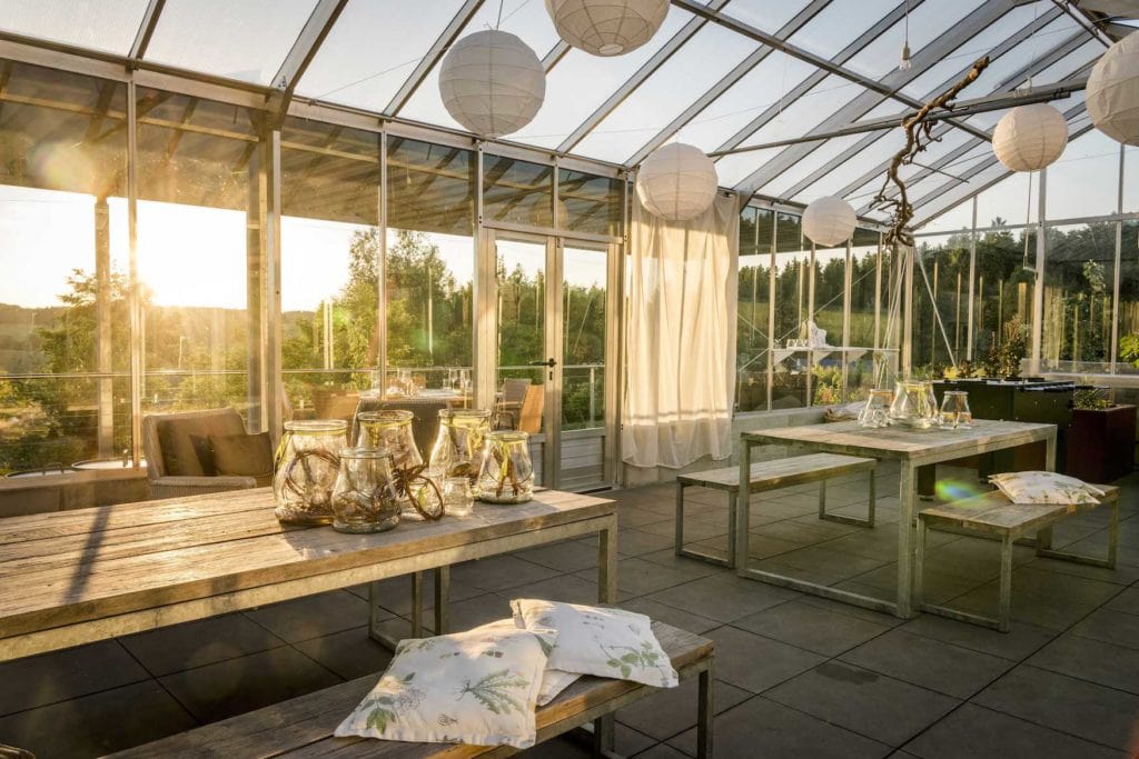 Glashaus mit schöner Dekoration spiegelt im Sonnenlicht