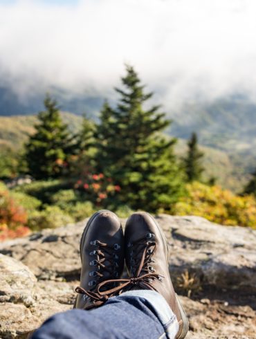 Wanderer ruht sich aus und fotografiert seine Wanderschuhe