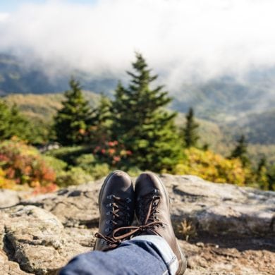 Wanderer ruht sich aus und fotografiert seine Wanderschuhe