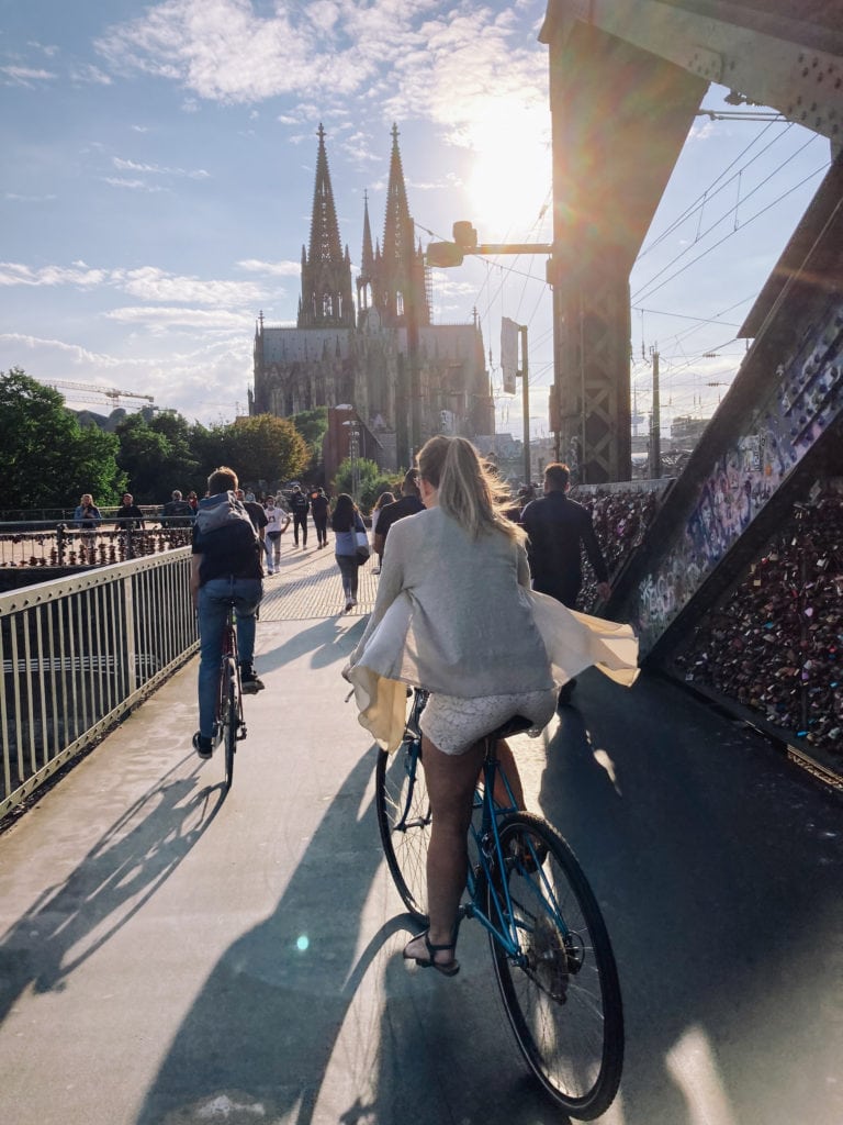 Fahrradfahrer fahren über Hohenzollernbrücke in Richtung Kölner Dom