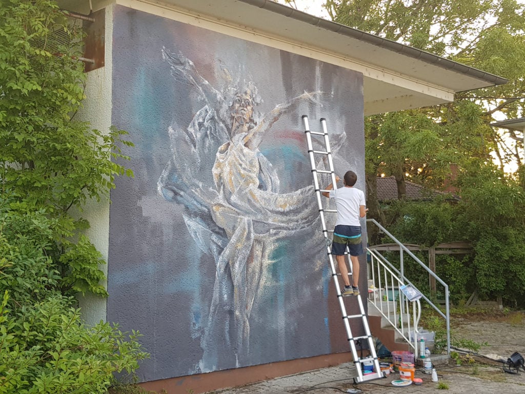 Künstler zeichnet Graffiti an Hauswand in Baden-Württemberg