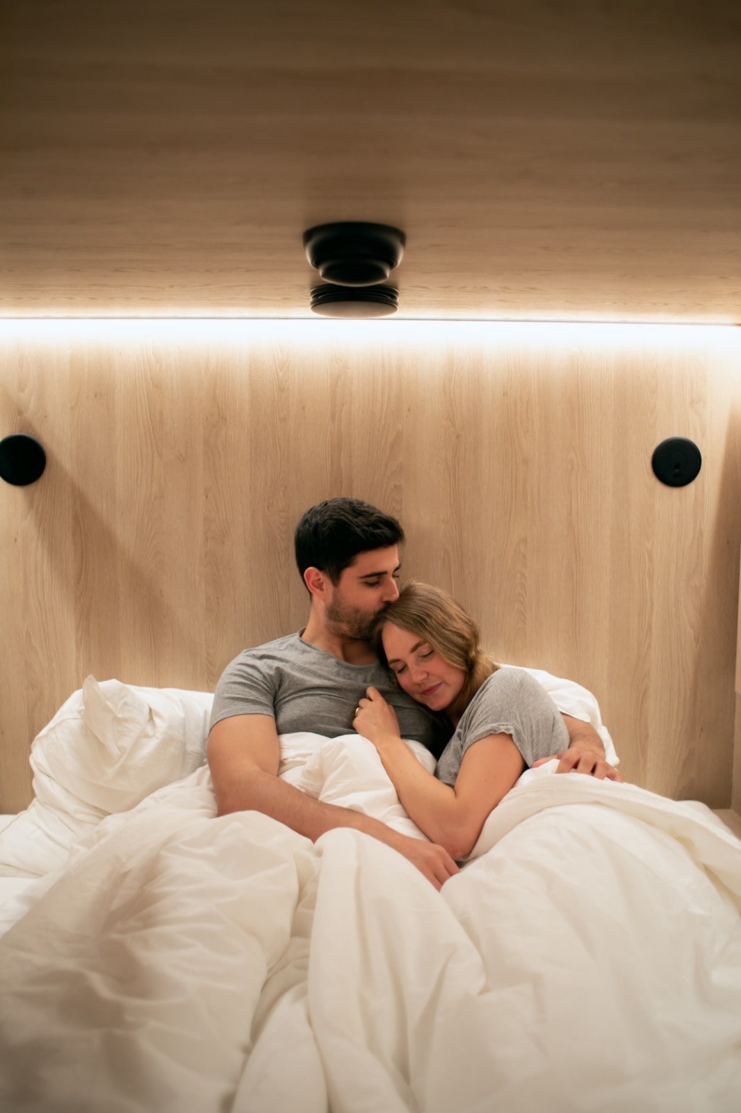 Couple lying in sleeping cabin and cuddling