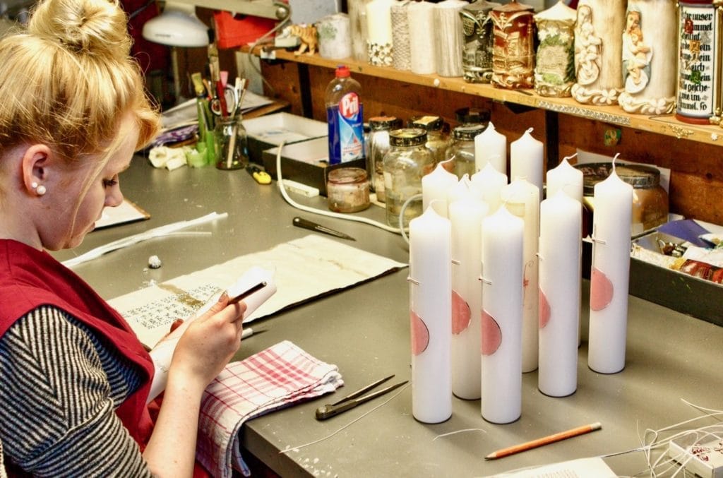 Frau gießt Kerzen in Kerzenmanufaktur Wiedemann, einem traditionellen Handwerk in Bayern