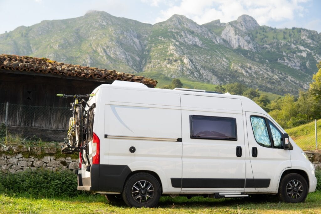 Ein ausgebauter Campingbus vor einem Bergpanorama