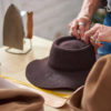 Mann produziert einen braunen Hut