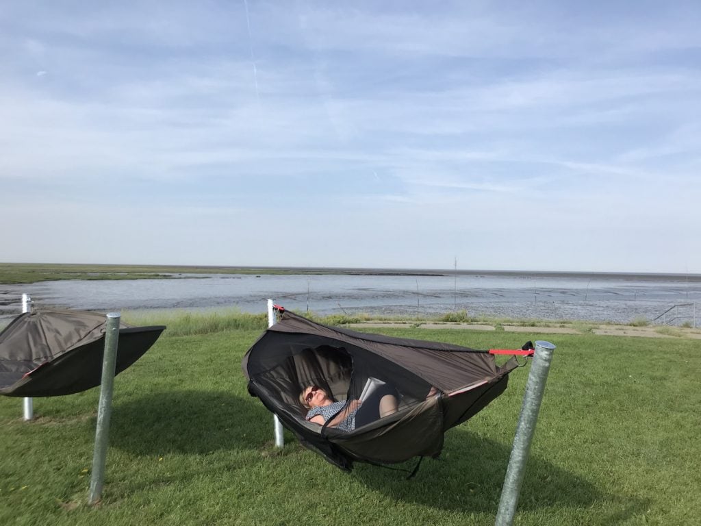 Woman in sleeping hammock on Wurster North Sea coast