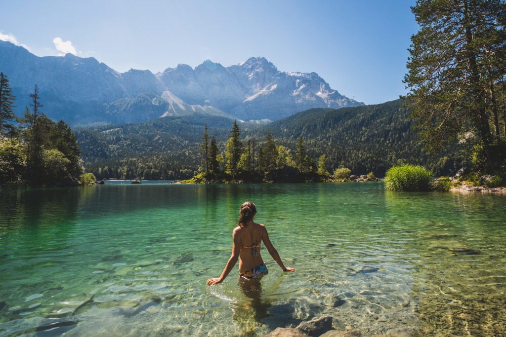 Mädchen geht in einem Bergsee in den Alpen schwimmen