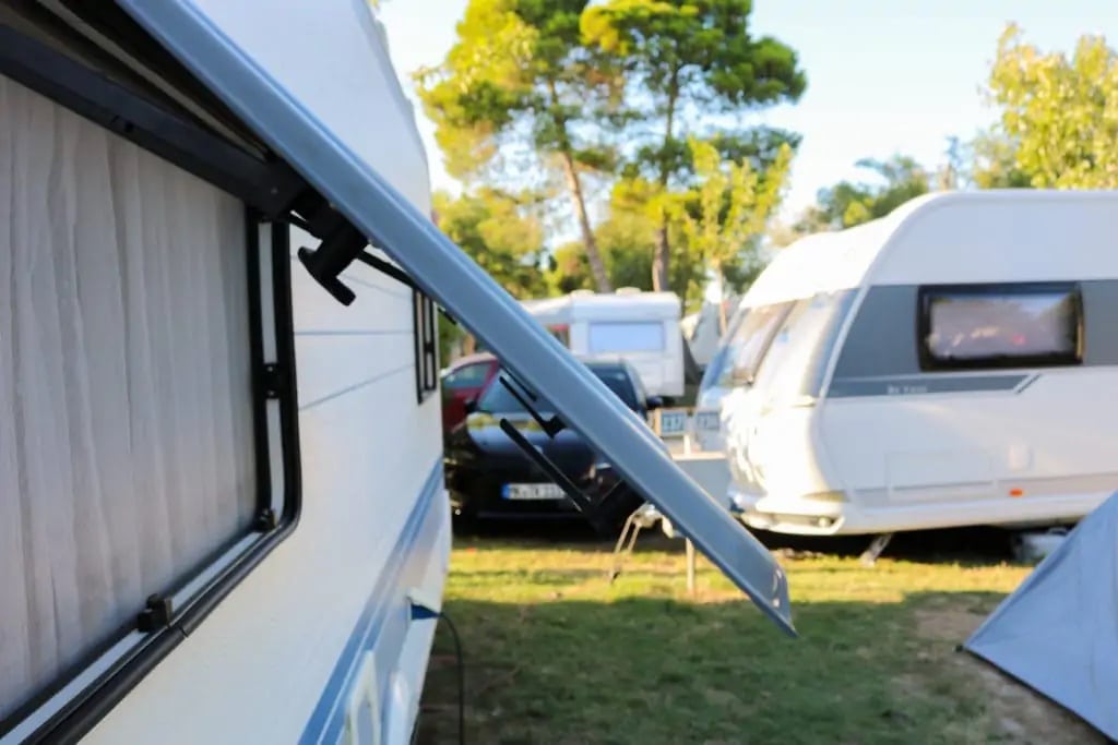 Open window of a camper on a campsite