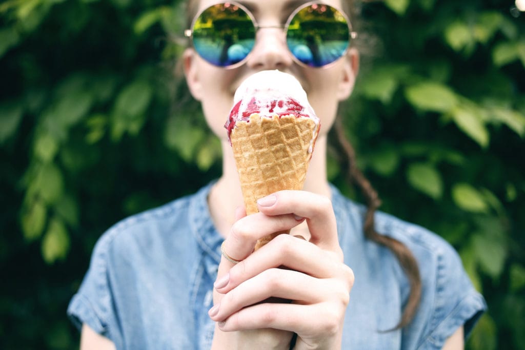 Frau mit Sonnenbrille isst Eis