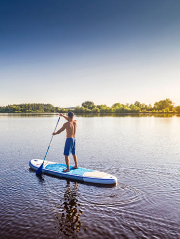 Stand Up Paddler auf einem See in Deutschland im Sommer