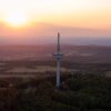 Drohnenaufnahme des Funkturms auf dem Vogelsberg in Hessen, im Hintergrund geht die Sonne unter