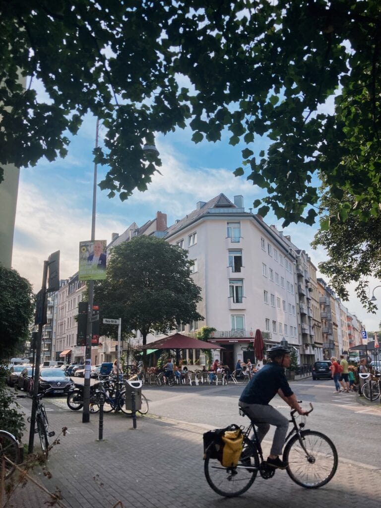 Man riding a bicycle in front of filos restaurant 