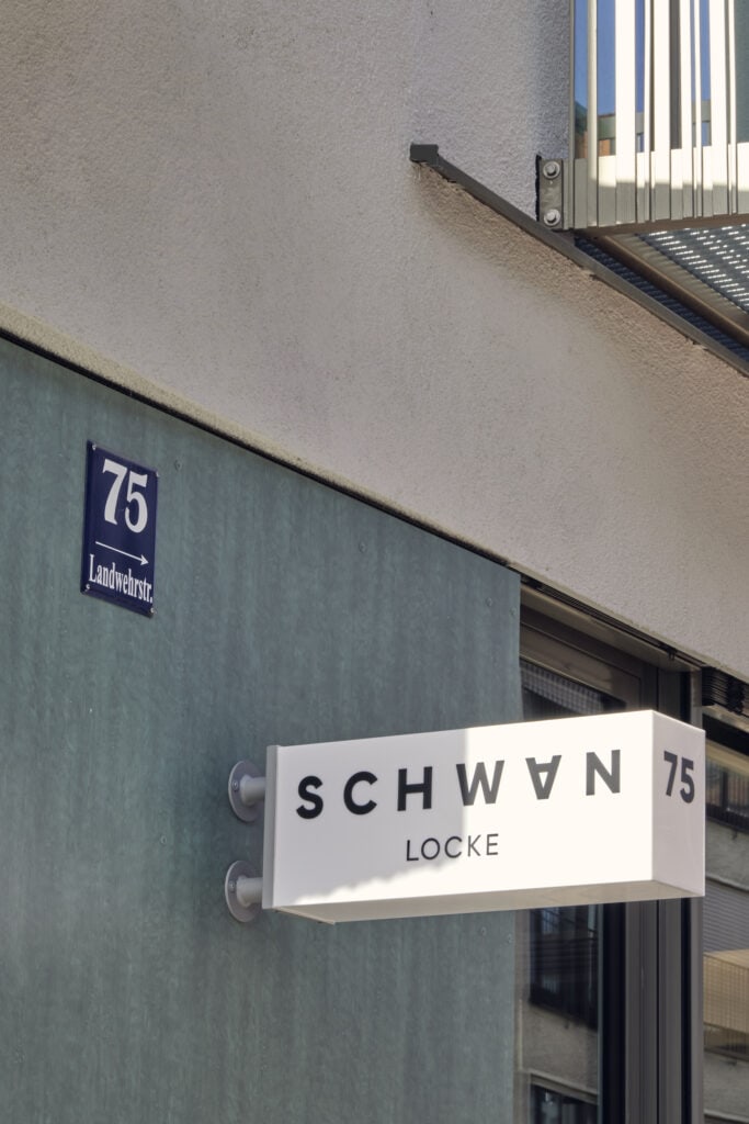 Schwan Locke Schild vor Hoteleingang