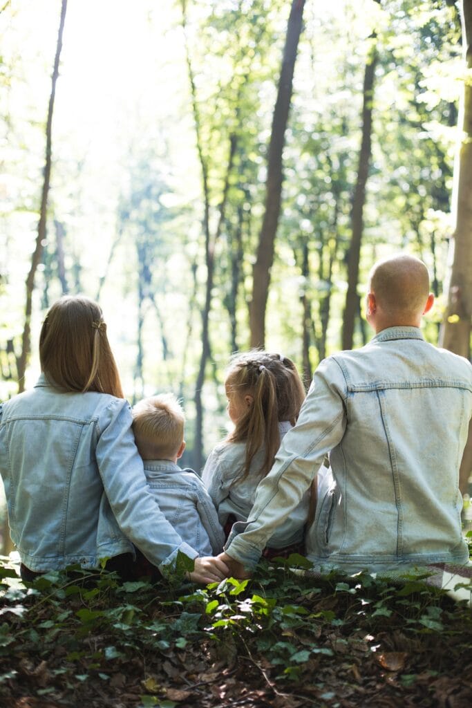 Familie sitzt in Wald