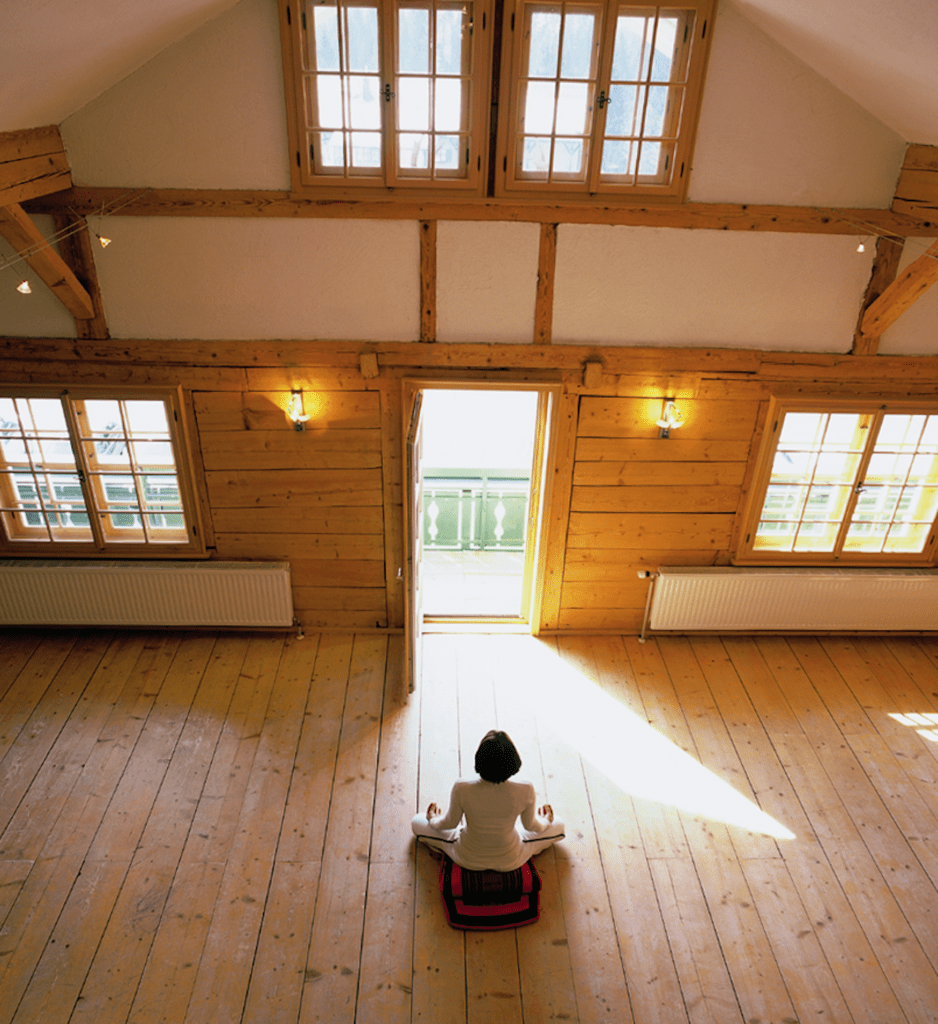Frau meditiert in den Yoga-Räumen des Hubertus Hotels im Allgäu