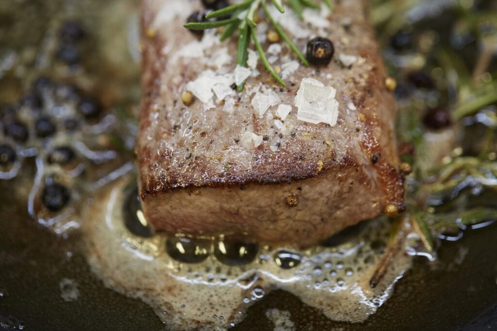 Served piece of meat with salt diamonds and rosemary