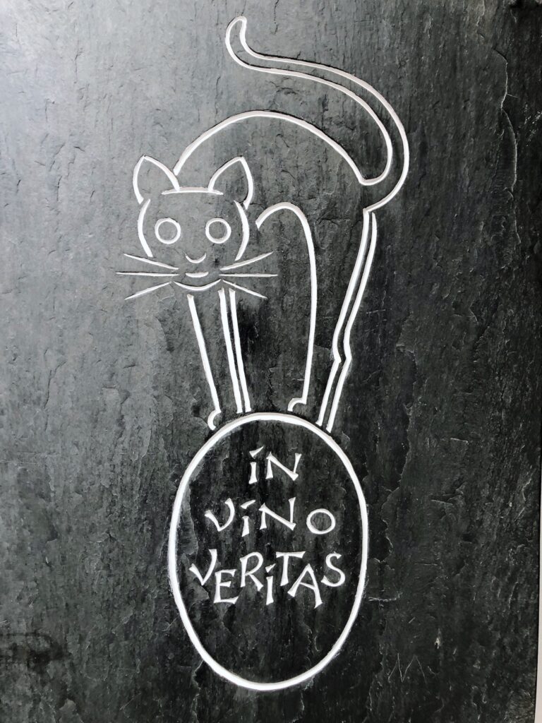 Katze auf Weinfass mit Schriftzug "In Vino Veritas"