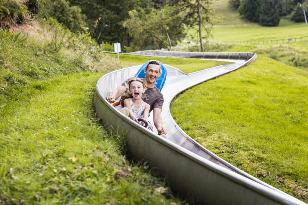 Father and daughter on a toboggan run in the Sankt Wendel County