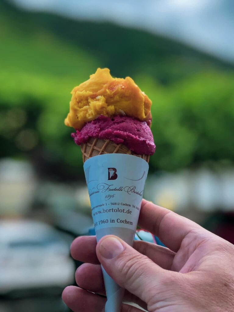 Man holding ice cream with two flavours in front of Moselle backdrop