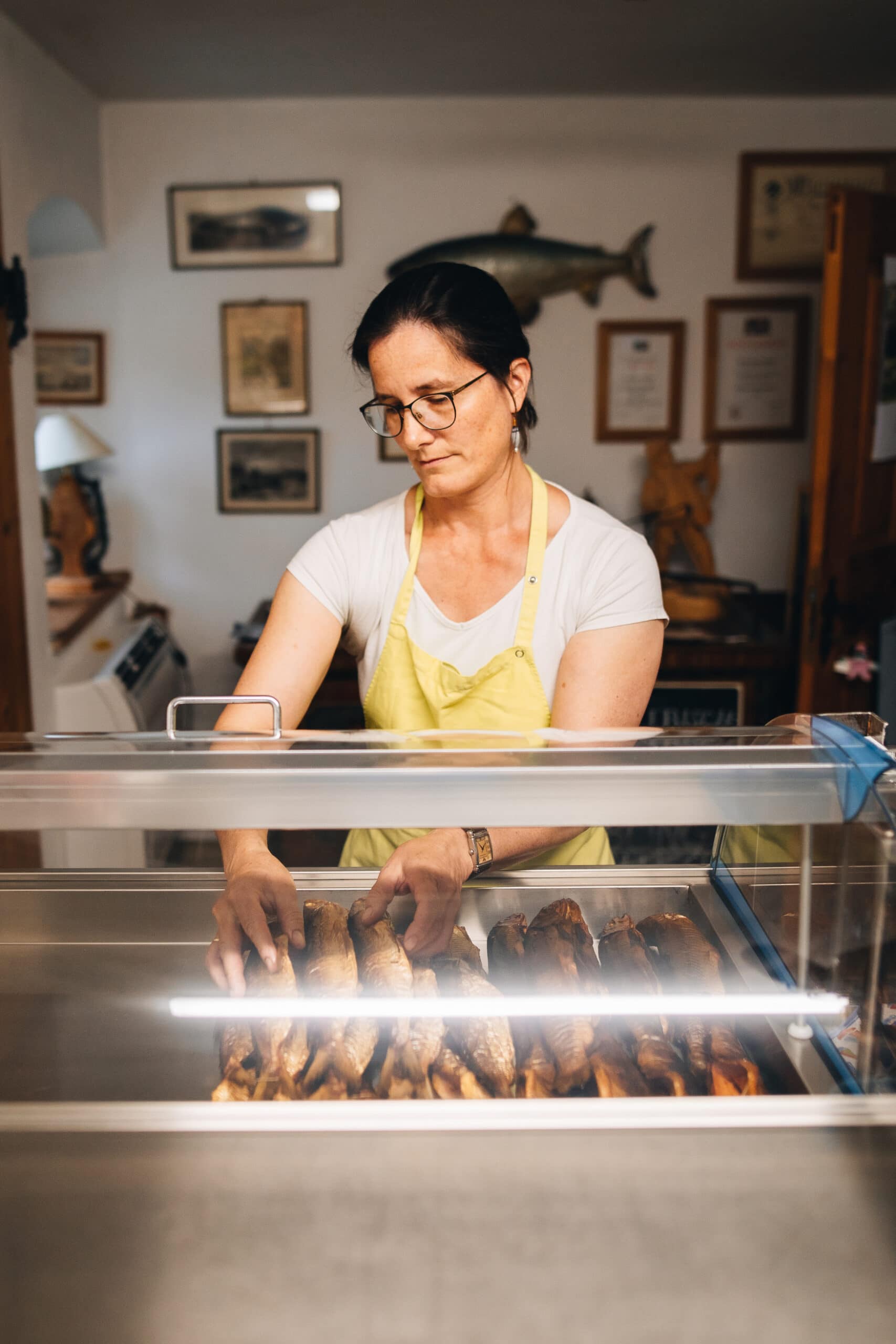 Frau serviert Steckerlfisch in einem Lokal im Chiemgau