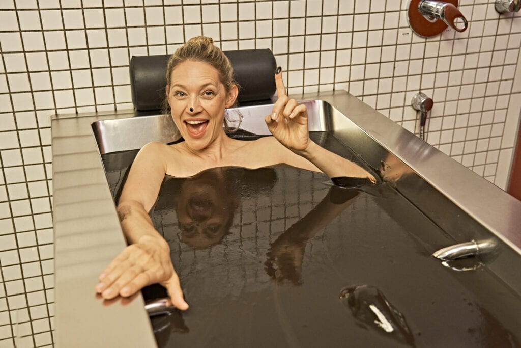 Frau badet in Naturmoor in der Limes-Therme in Bad Gögging