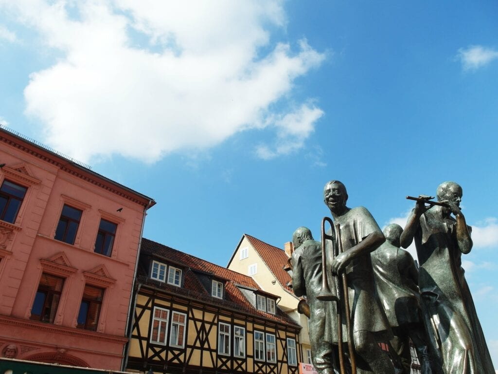 Bronze statue of the Münzenberg Musicians on the market square in Quedlinburg, lively northern German town known for medieval streets lined with half-timbered house
