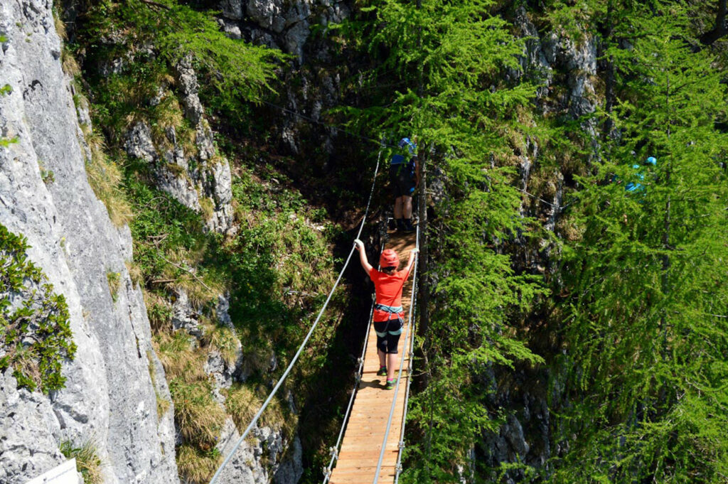 Frau auf einer Hängebrücke am Schützensteig, einem der besten Klettersteige in Berchtesgaden