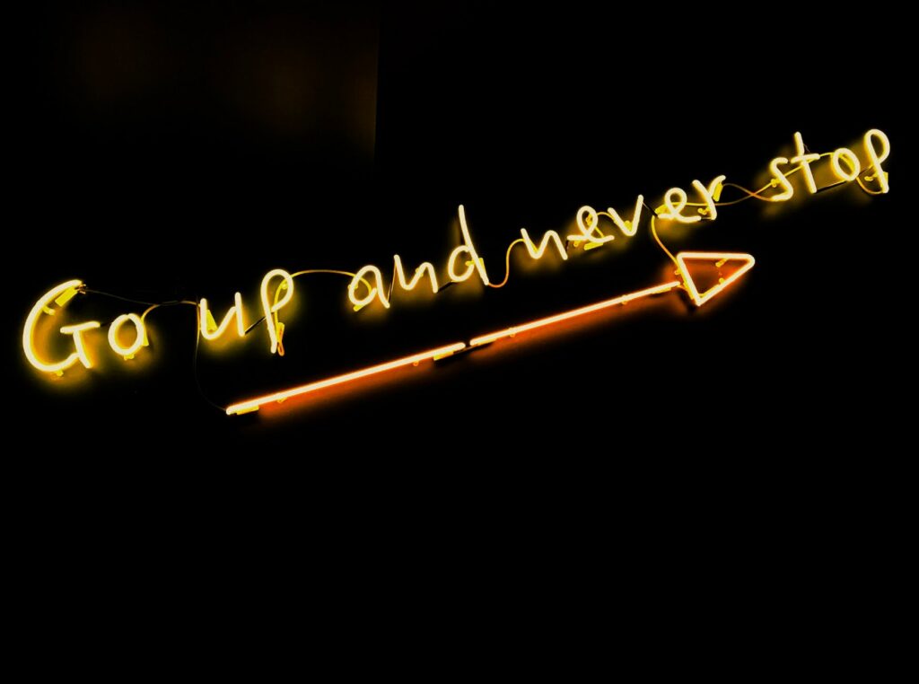 Neon Schild mit der Aufschrift Go up and never stop