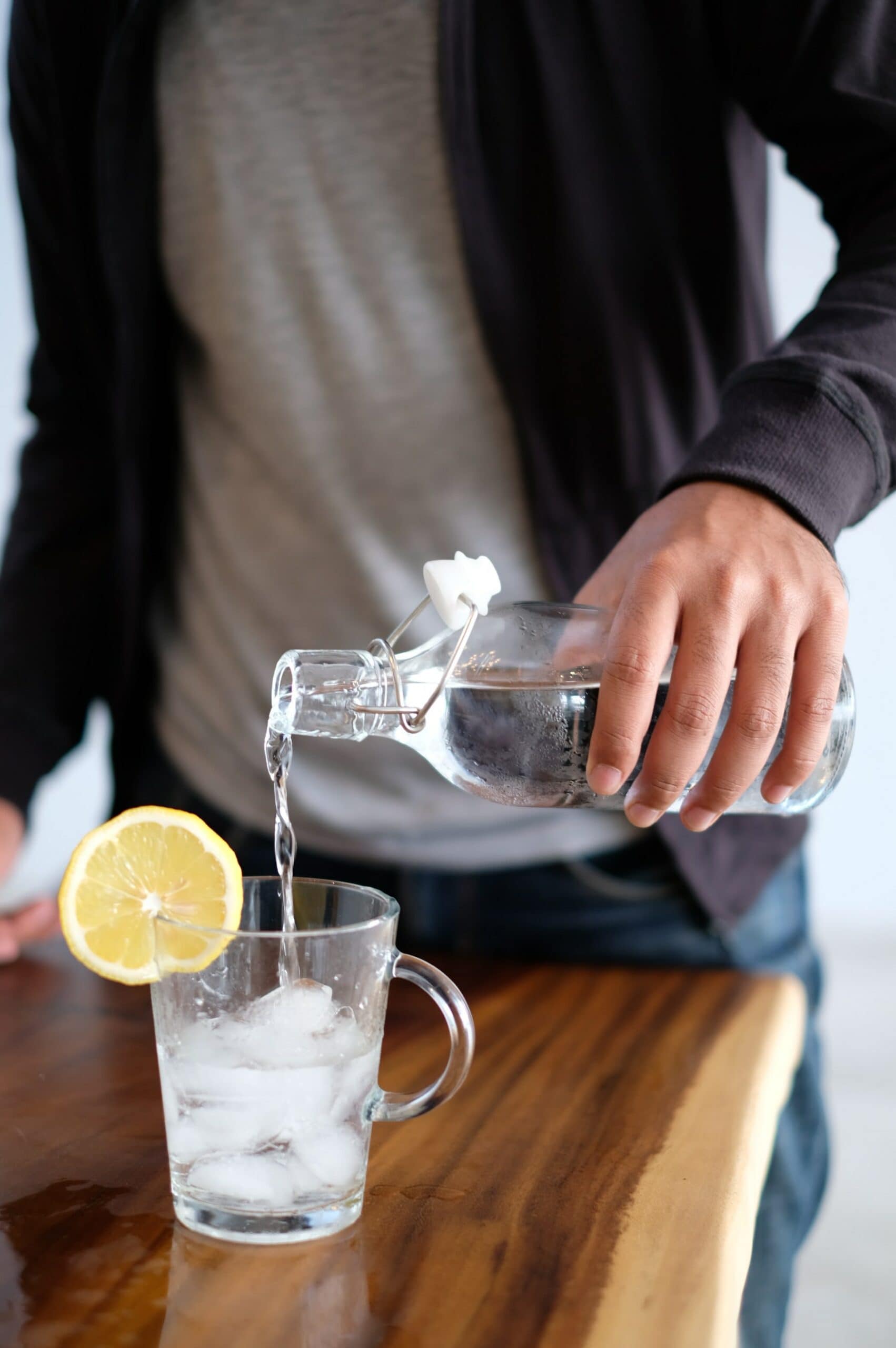 Mann trinkt infused Water mit Zitrone, einer unserer Tipps gegen Hitze