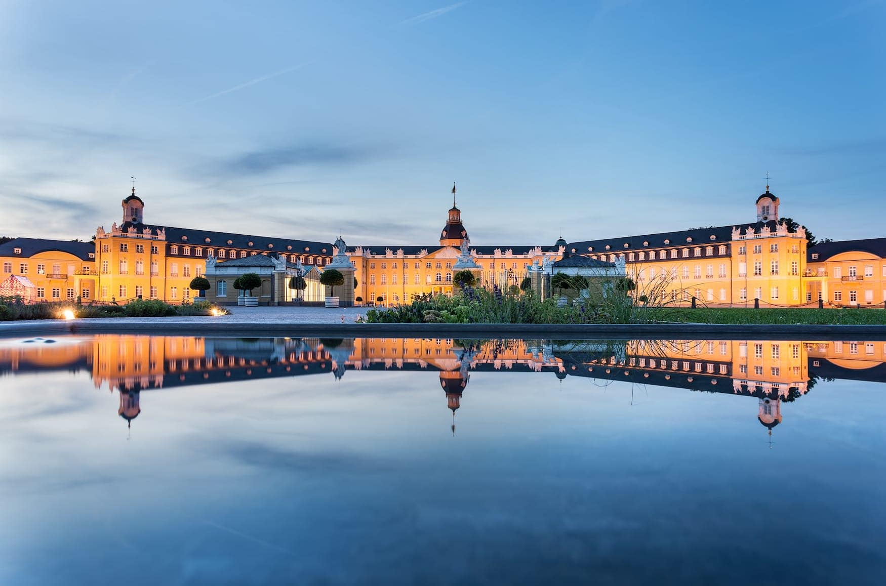 Karlsruhe castle reflected in water in summer evening