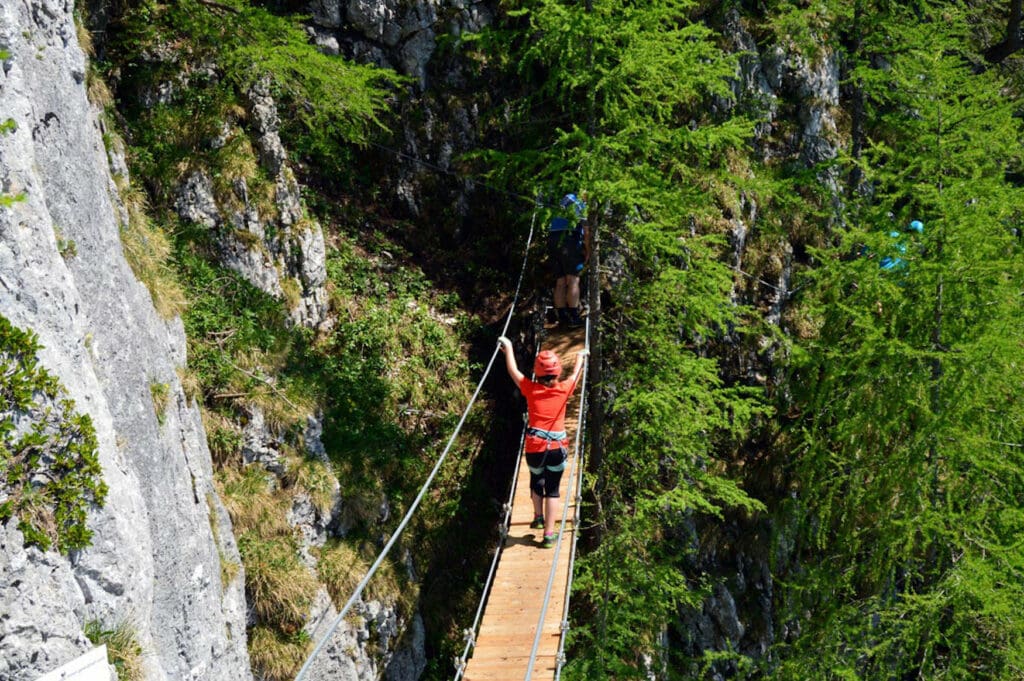 Woman on a suspension bridge on the Schützensteig, one of the best via ferratas in Berchtesgaden